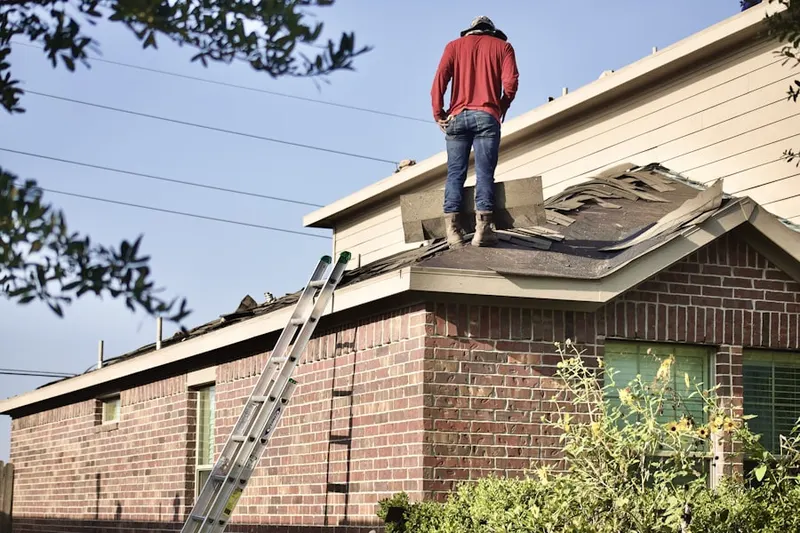 Professional roofer working on a residential roof in Top Road
